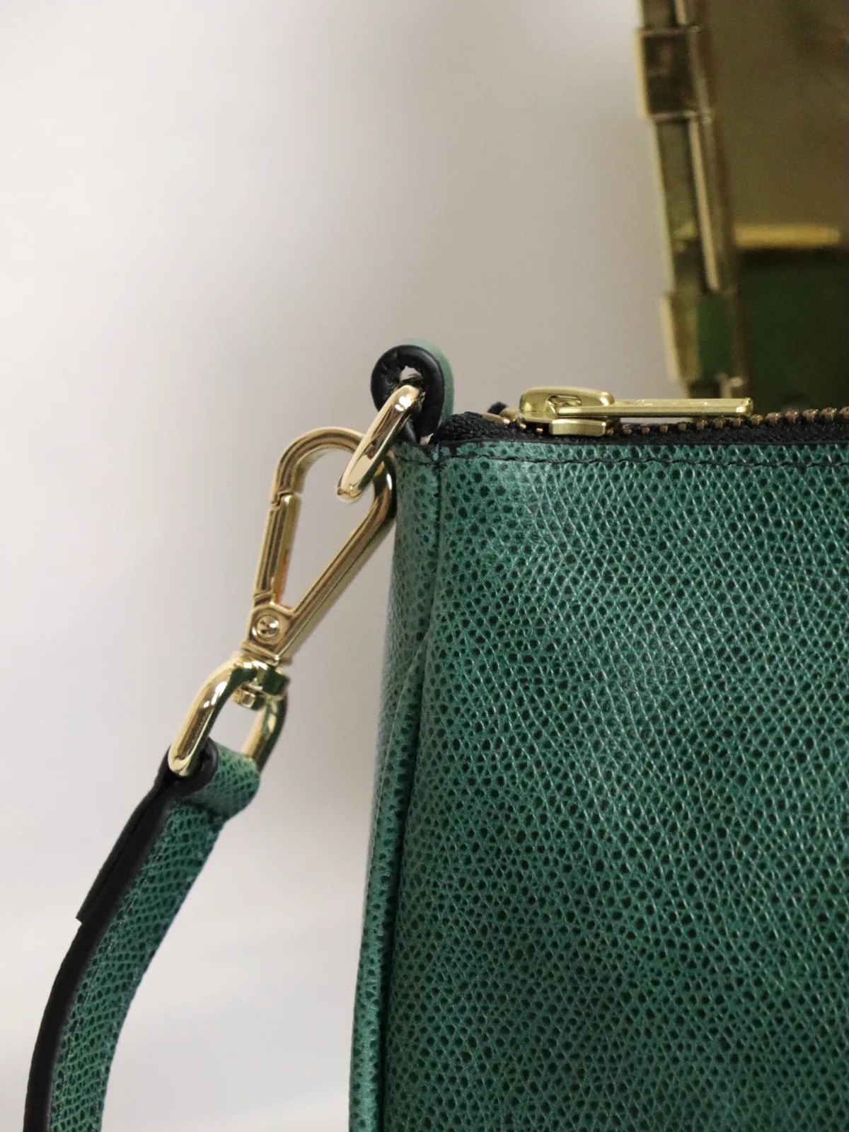 Bolso de mano de piel grabada verde con cierre y mosquetón dorados y asa desmontable